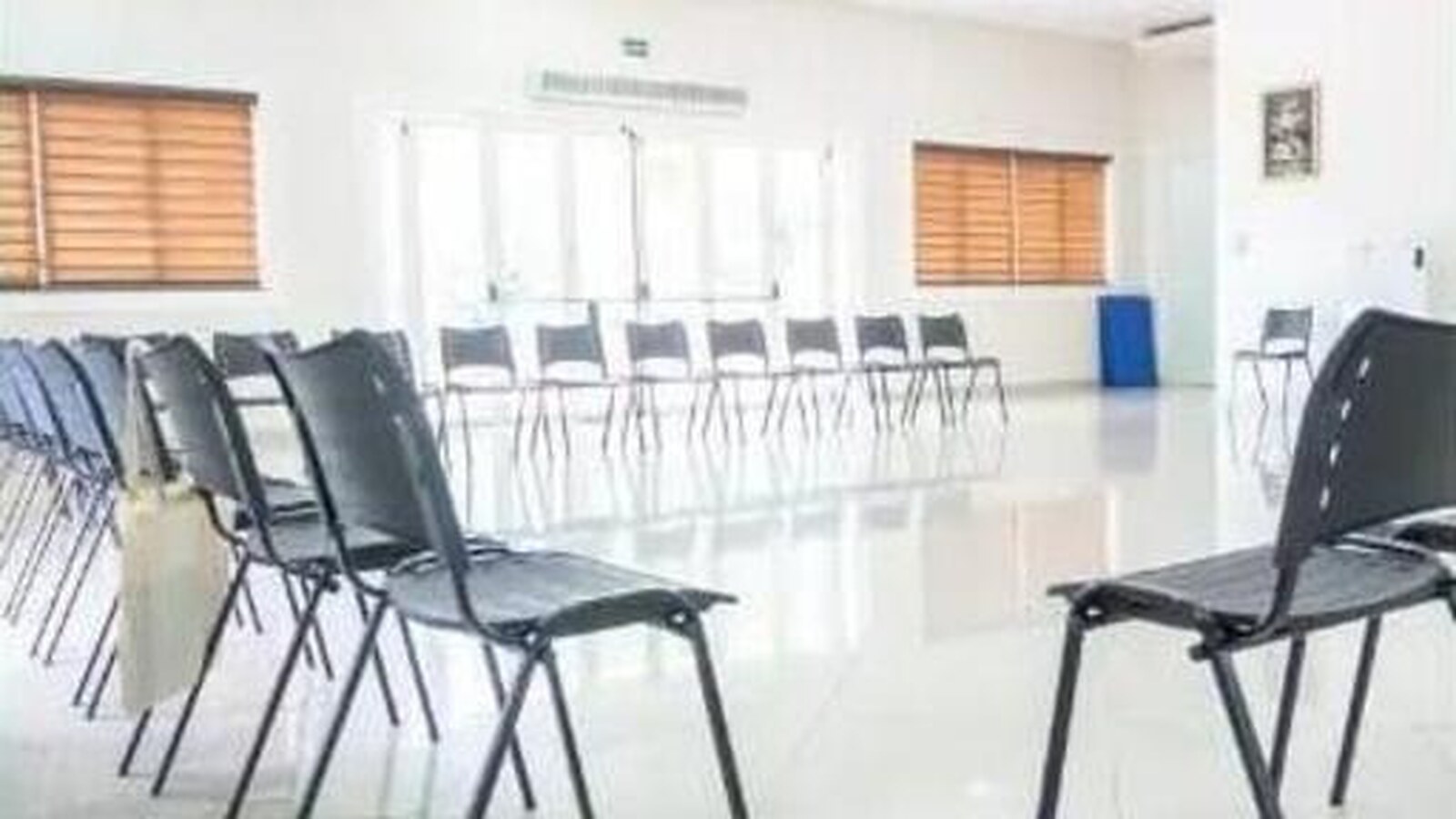 Sala de atividades com cadeiras enfileiradas em ambiente amplo e iluminado